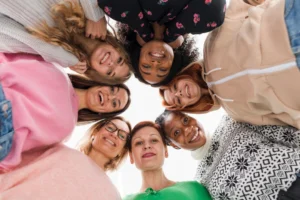 A group of diverse women smiling in a supportive circle, symbolizing friendship and community in Los Angeles.